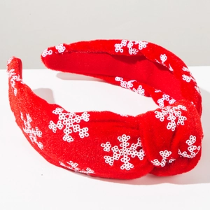 Detail of red Christmas headband featuring knotted velvet and white sequin snowflakes