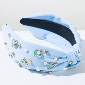 Detail van een lichtblauwe hoofdband met zeesterren, schelpen, parels en strass