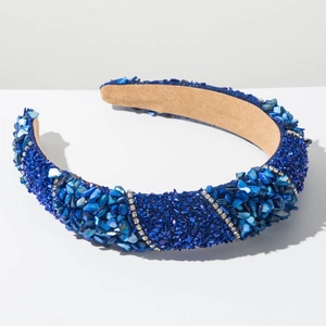 Close-up of wide padded headband with blue rhinestones, crushed stones and silver crystals