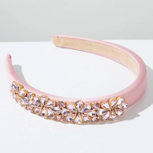 Detailansicht des rosa Satin Stirnbands mit Kristallblumen und goldenen Fassungen