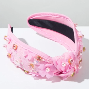 Détail du serre-tête rose en tissu avec fleurs 3D, perles fantaisie et strass brillants