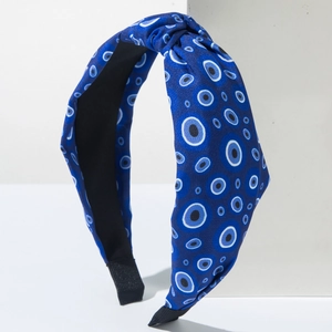 Detail of blue top knot headband featuring white and light blue evil eye pattern prints