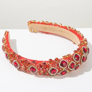 Macro detail of luxury baroque headband with red crystals and gold-tone rhinestone settings