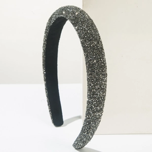Detailed view of luxury padded headband with shimmering grey rhinestones on a white stand