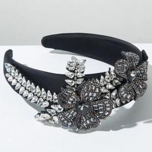 Detailaufnahme von luxuriösem schwarzen Stoffstirnband mit Kristallblumen und Blättern