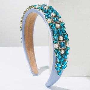 Baroque velvet headband with blue crystals and pearls on a white minimalist pedestal