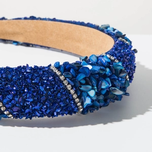 Close-up of luxury dark blue headband with crushed stones, shells and crystal rhinestones