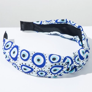 Detail of fabric headband featuring blue evil eye print and stylish top knot design