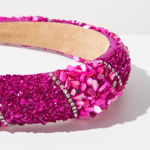 Detailed macro shot of fuchsia wide headband with colorful stones and sequins