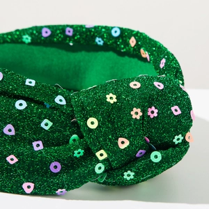 Macro shot of green glitter headband with colorful sequins and twisted knot detail