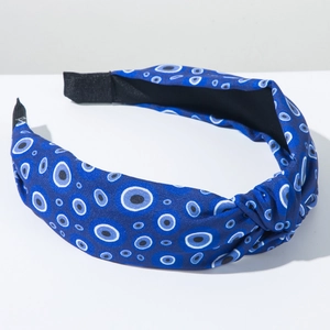 Close-up of blue headband featuring evil eye print with top knot detail and non-slip lining
