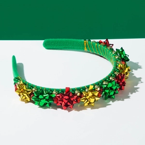 Close-up of Christmas headband with shiny metallic gift bows and green velvet texture