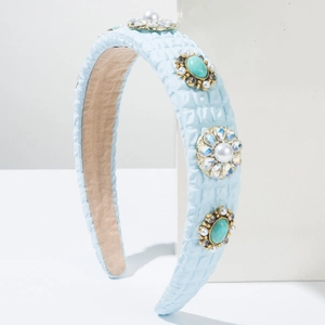 Detail of light blue quilted headband featuring elegant pearl and rhinestone ornaments