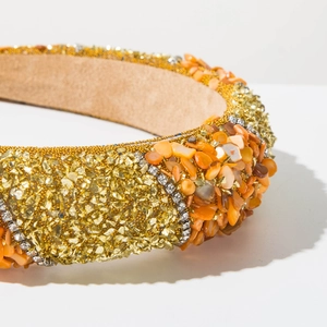 Detailed macro view of the rhinestone edges and orange stone textures on the headband