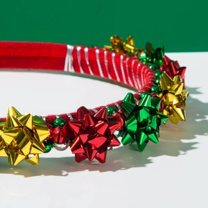 Detailed close-up of festive Christmas headband with bells and colorful gift flower decor