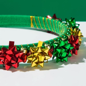 Detail of Christmas headband with colorful bows, gold bells, and festive floral ornaments