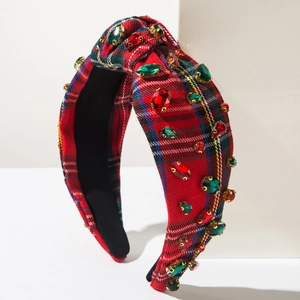 Détail d'un serre-tête en tartan rouge orné de strass brillants pour les fêtes de Noël