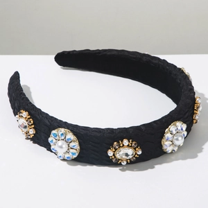 Detail of elegant black headband with pearls and crystals on textured gold base settings