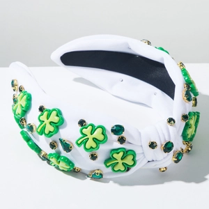 Détail du serre-tête en tissu blanc avec trèfles verts et strass étincelants