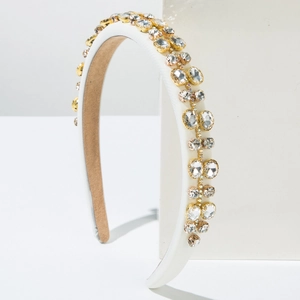 White padded headband with sparkling crystals and satin finish on a minimalist display