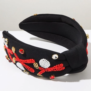 Close-up of handmade beaded headband with red coral patterns and crystal rhinestones