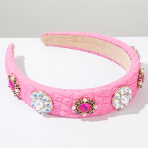 Detail of pink embossed fabric headband featuring rhinestones and faux pearl floral patterns