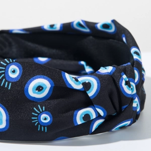 Detailed close-up of knot headband with blue and white Evil Eye pattern on black fabric