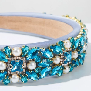 Detail of luxury baroque headband with blue crystals and white pearls on satin fabric