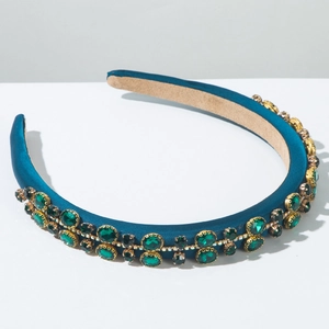 Detailed macro view of peacock blue satin headband with inlaid green crystal rhinestones