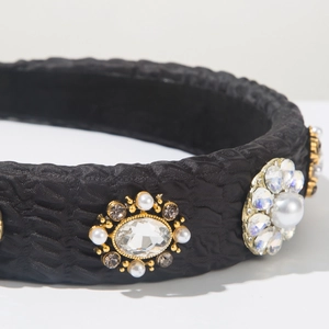 Detail of black snake-textured headband featuring white pearls and clear rhinestones