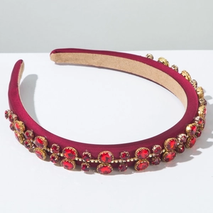 Detail view of burgundy satin headband with red rhinestones and golden claw settings