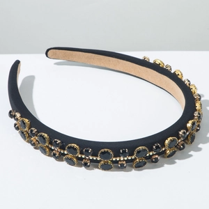 Detailed macro shot of elegant black velvet headband with gold-plated rhinestone rows