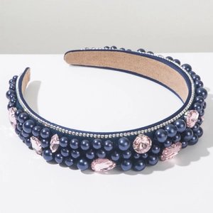 Détail du serre-tête en velours avec perles marines et cristaux roses sur fond blanc