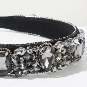Détails de cristaux cousus main et strass sur un bandeau baroque en velours noir
