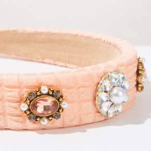 Close-up of light pink padded headband with quilted texture, pearls and rhinestones