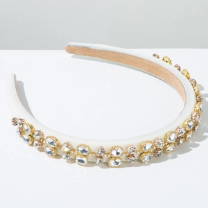 Detail of white satin headband with handcrafted rhinestones and golden metal claw settings