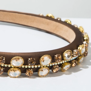 Macro view of luxury brown fabric headband with amber crystals and sparkling rhinestones
