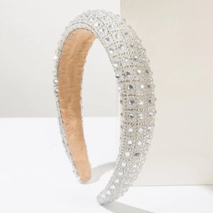 Detail of wide sparkling headband with clear rhinestones and beige suede lining