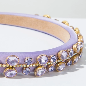 Detail of purple padded headband featuring lavender satin and large faceted crystals
