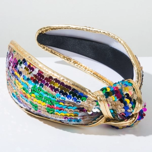Close-up of colorful sequins and gold metallic fabric knot on a wide headband