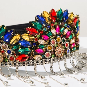 Close-up of luxury Baroque crown with colorful gemstones and silver rhinestone tassels