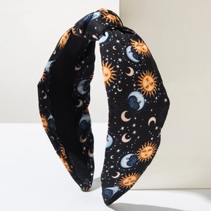 Retro knotted wide headband featuring gold sun and moon celestial prints on black fabric