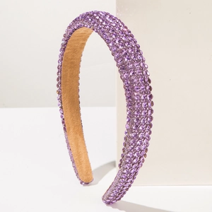 Close-up of sparkling purple rhinestone padded headband with soft brown velvet lining