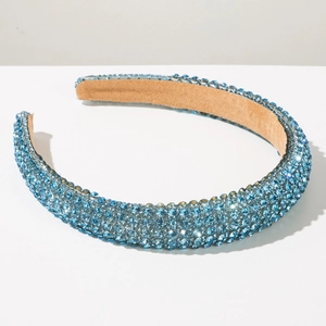 Detail of light blue padded headband featuring dense sparkling rhinestones and velvet lining