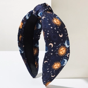 Retro knotted headband in navy blue fabric with celestial sun and moon patterns