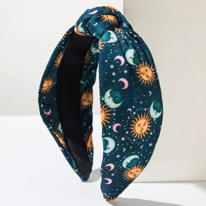 Close-up of knot headband featuring bohemian sun, moon and star patterns on teal fabric