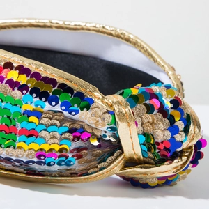 Close-up detail of colorful sequins and gold trim on the knot headband for parties