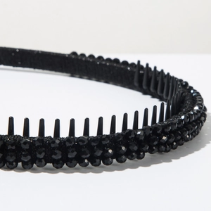 Close-up of black beaded headband with anti-slip inner teeth and textured fabric finish