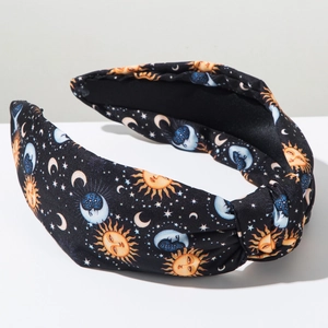 Detailed view of wide knotted headband with celestial sun moon and stars print pattern