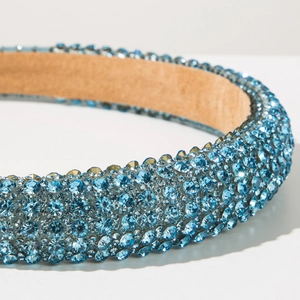 Close-up of a wide sponge headband featuring shimmering light blue rhinestones and velvet lining